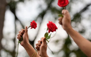 Women holdina red rose into the sky
