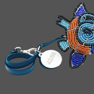 Colorful beaded keychain with a blue strap on a white background