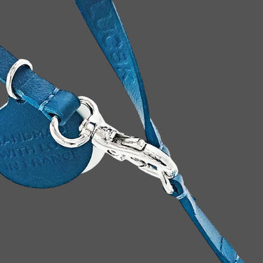 Blue leather strap with silver hardware on a white background
